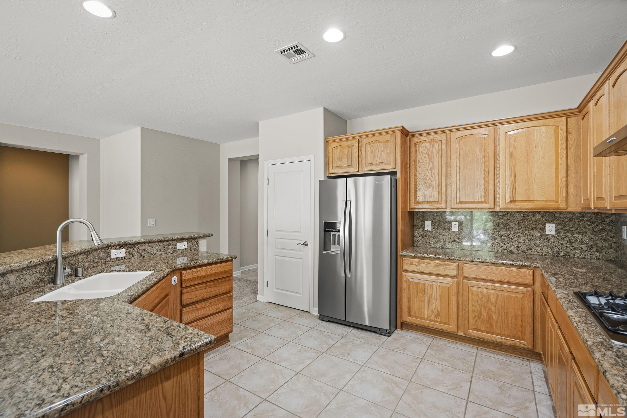 9195 Heritage Ridge Court Reno, NV 89523 - Photo 8 of 30 a kitchen with stainless steel appliances granite countertop a sink stove and refrigerator