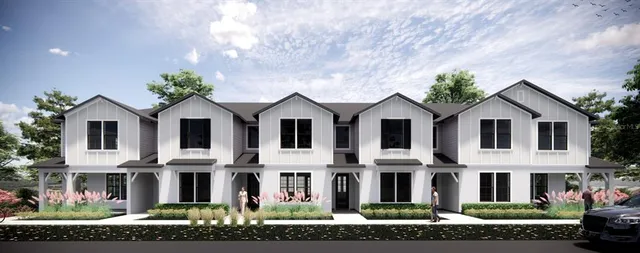 a view of a white house with large windows and a yard