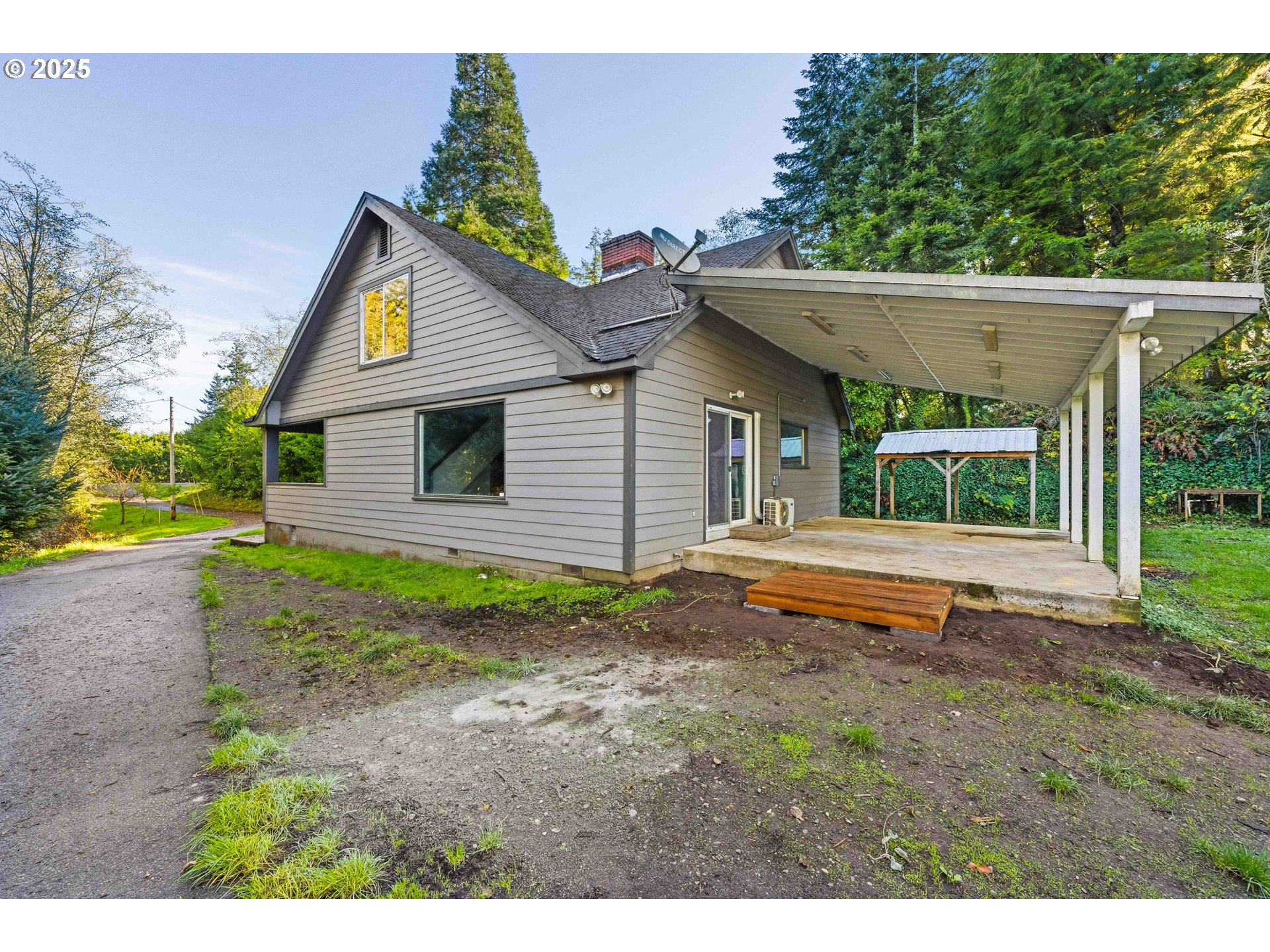 a backyard of a house with plants and wooden fence
