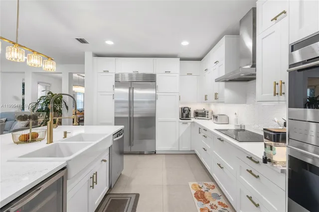 a large white kitchen with sink and white cabinets