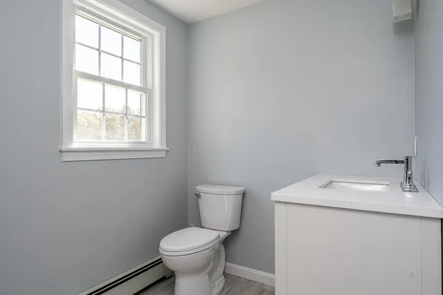 a bathroom with a sink toilet and window