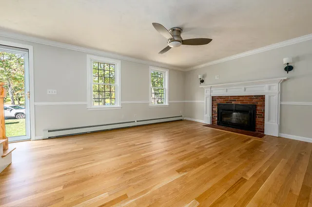 a view of an empty room with a fireplace and a window