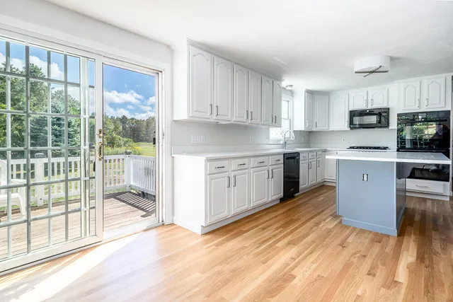 a kitchen with stainless steel appliances granite countertop a stove a sink dishwasher and a refrigerator with wooden floor