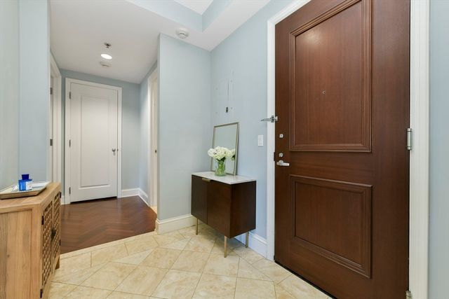 a view of a hallway with bathroom and wooden floor