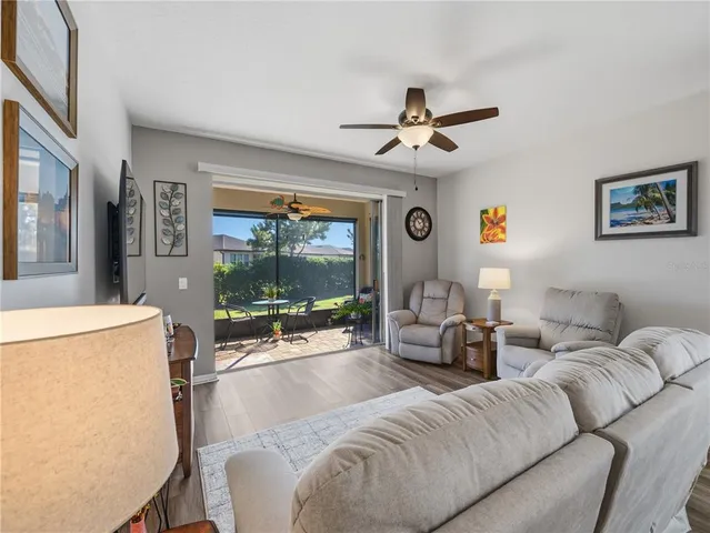 a living room with furniture a flat screen tv and a large window