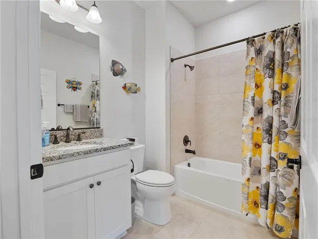 a bathroom with a granite countertop sink a toilet and shower