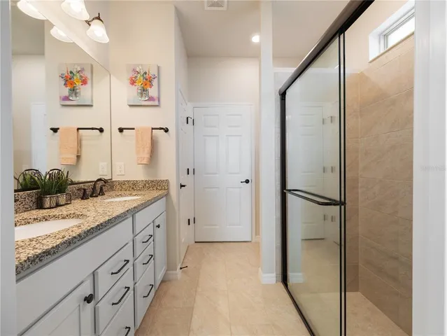 a spacious bathroom with a granite countertop sink mirror and shower