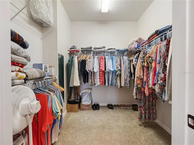 a view of walk in closet with clothes and shoes