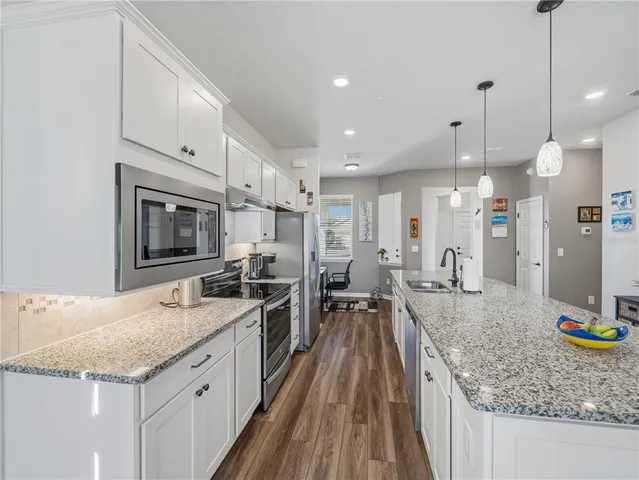 a kitchen with sink stove and refrigerator