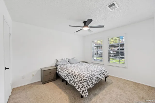 a bedroom with a bed and a ceiling fan