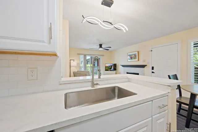 a close view of a sink and dishwasher with kitchen island