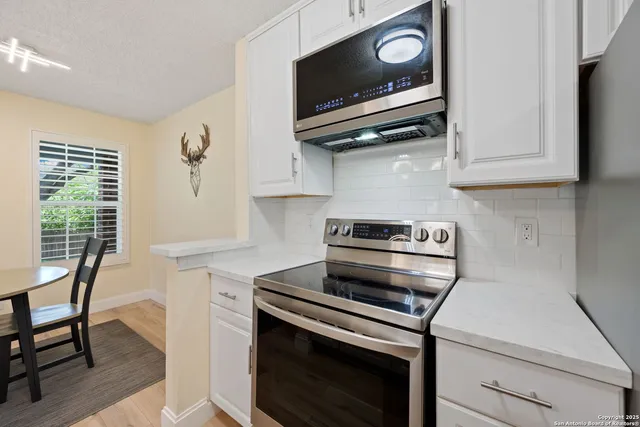 a kitchen with wooden floor and a stove top oven