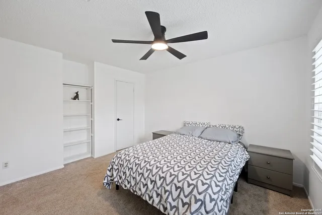 a bedroom with a bed and a ceiling fan