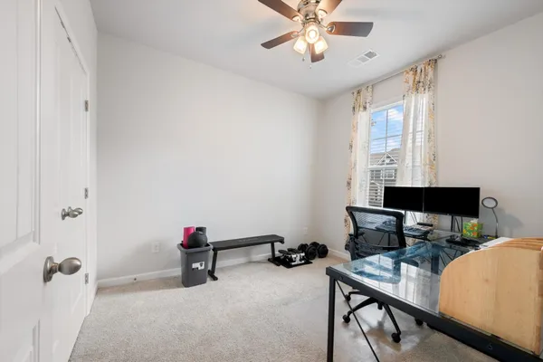 a view of a workspace with furniture and a window