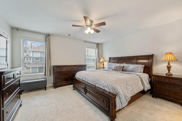 a spacious bedroom with a bed and a chandelier