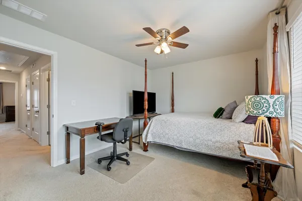 a bedroom with a bed desk and chair
