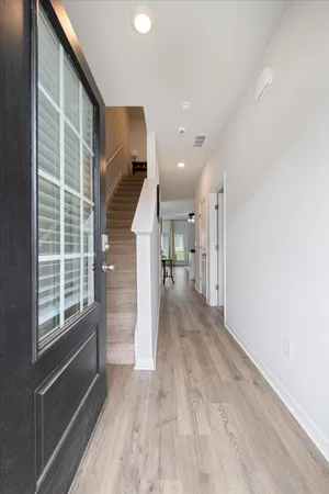a view of hallway with wooden floor and stairs