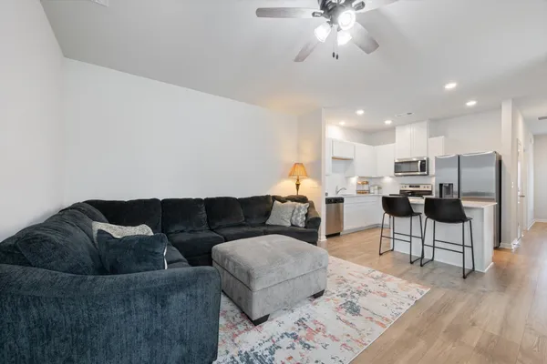 a living room with furniture and kitchen view