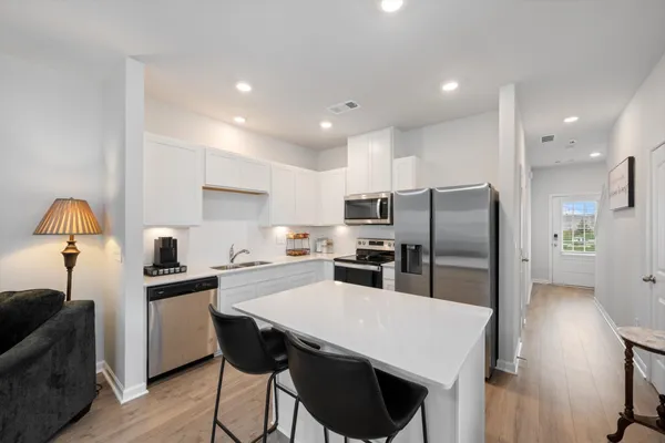 a kitchen with refrigerator cabinets dining table and chairs