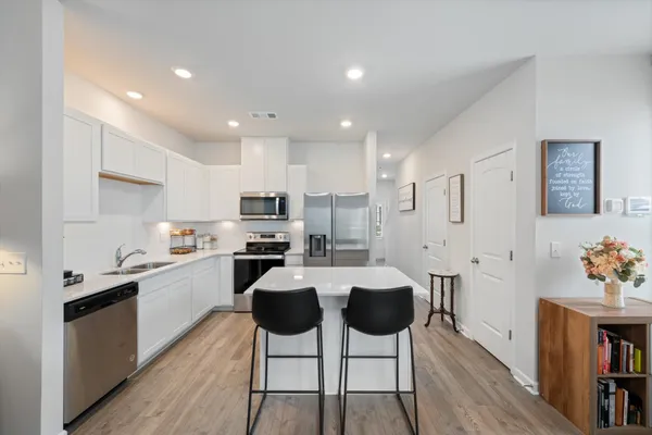 a kitchen with stainless steel appliances kitchen island granite countertop a sink and cabinets