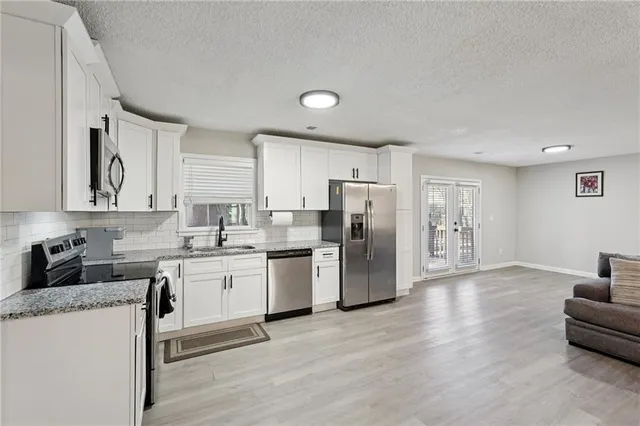 a kitchen with refrigerator and cabinets