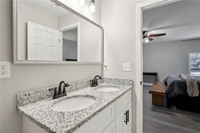 a bathroom with a granite countertop sink a mirror and vanity