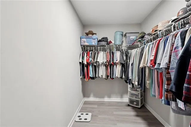 a view of walk in closet with clothes and shoes