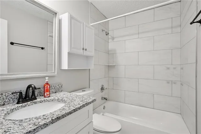 a bathroom with a granite countertop bathtub sink vanity and tub