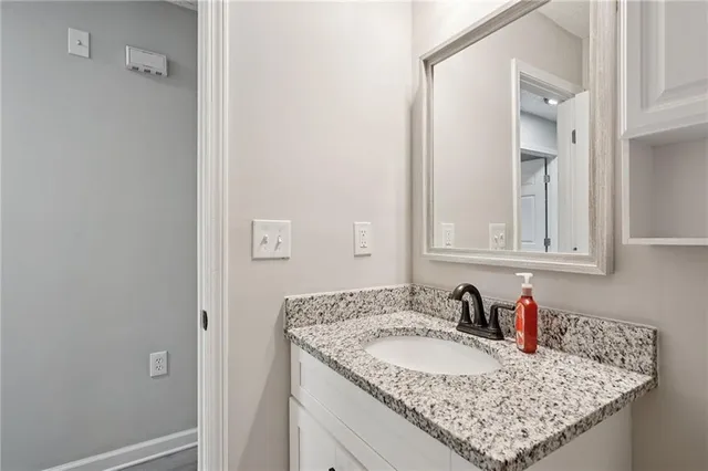 a bathroom with a granite countertop sink and a mirror