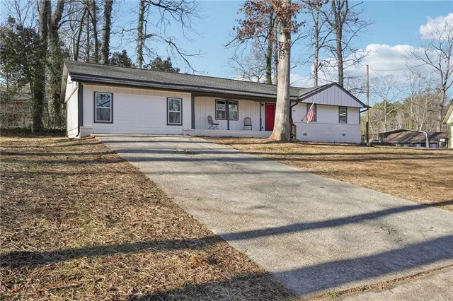 a view of a house with a yard and large tree