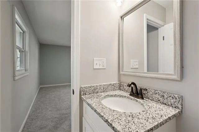 a bathroom with a granite countertop sink and a mirror