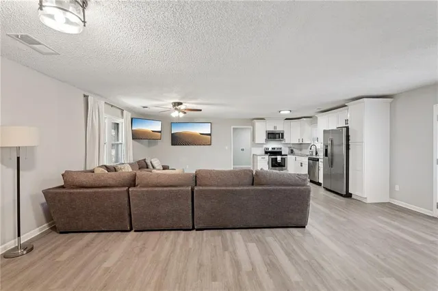 a living room with furniture and a wooden floor
