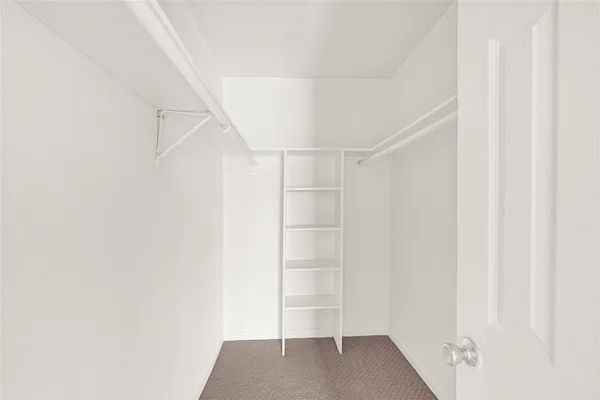 a view of walk in closet with empty racks