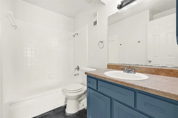 a bathroom with a granite countertop sink a toilet and bathtub