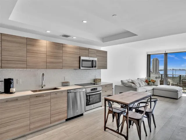 a kitchen with a table chairs sink and cabinets