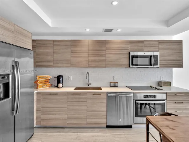 a kitchen with stainless steel appliances granite countertop a sink stove and refrigerator