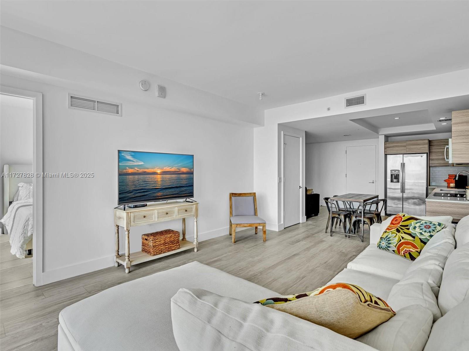 121 Northeast 34th Street, Unit 1005 Miami, FL 33137 - Photo 19 of 44 a living room with furniture and a flat screen tv