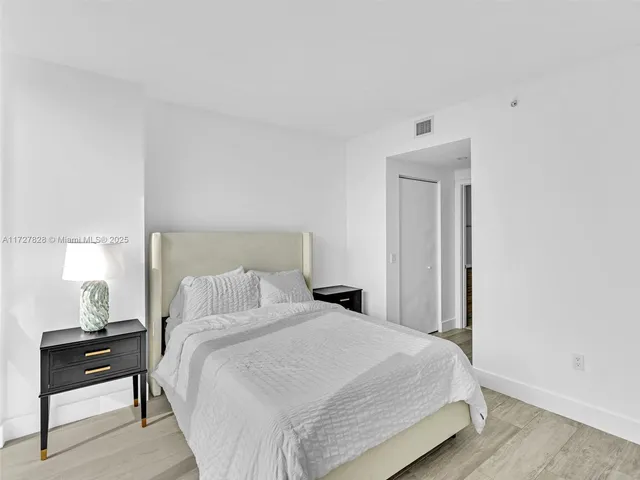 a bedroom with a bed and a night stand