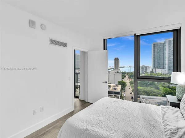 a bedroom with a bed and a dresser with mirror