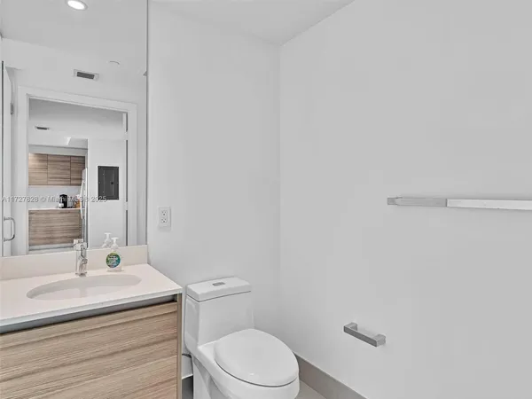 a bathroom with a sink a toilet and mirror