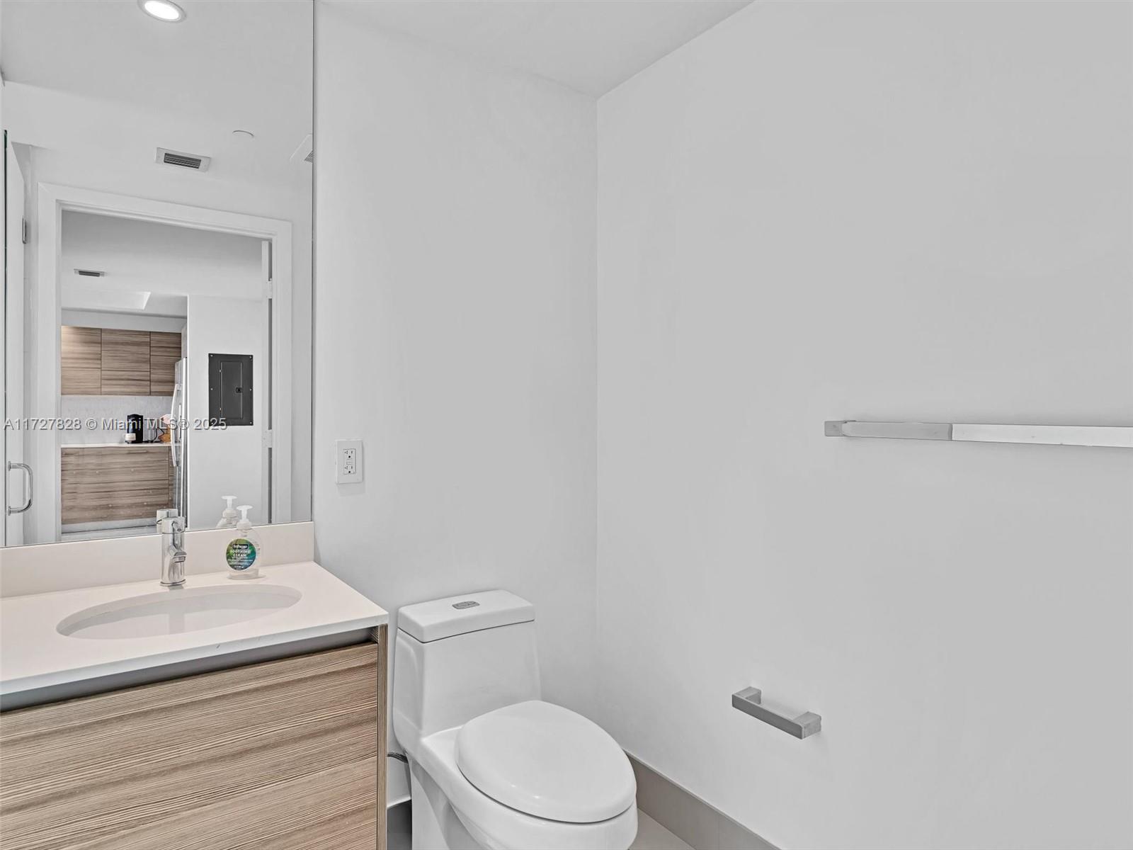 121 Northeast 34th Street, Unit 1005 Miami, FL 33137 - Photo 24 of 44 a bathroom with a sink a toilet and mirror