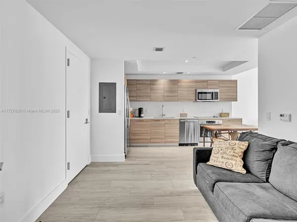 a living room with stainless steel appliances kitchen island granite countertop furniture and a view of kitchen