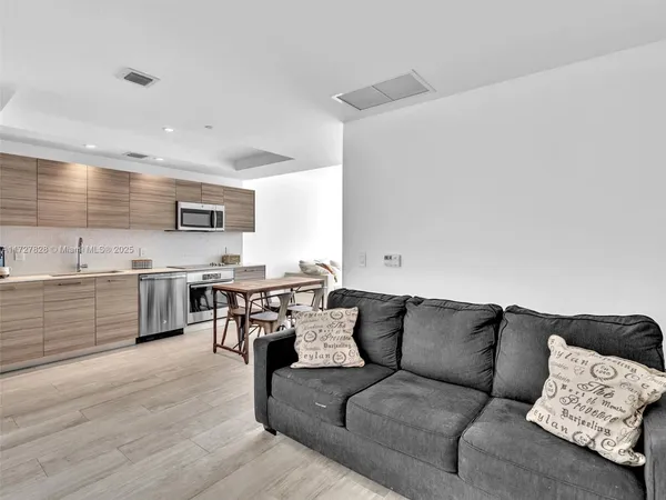 a living room with furniture and kitchen view