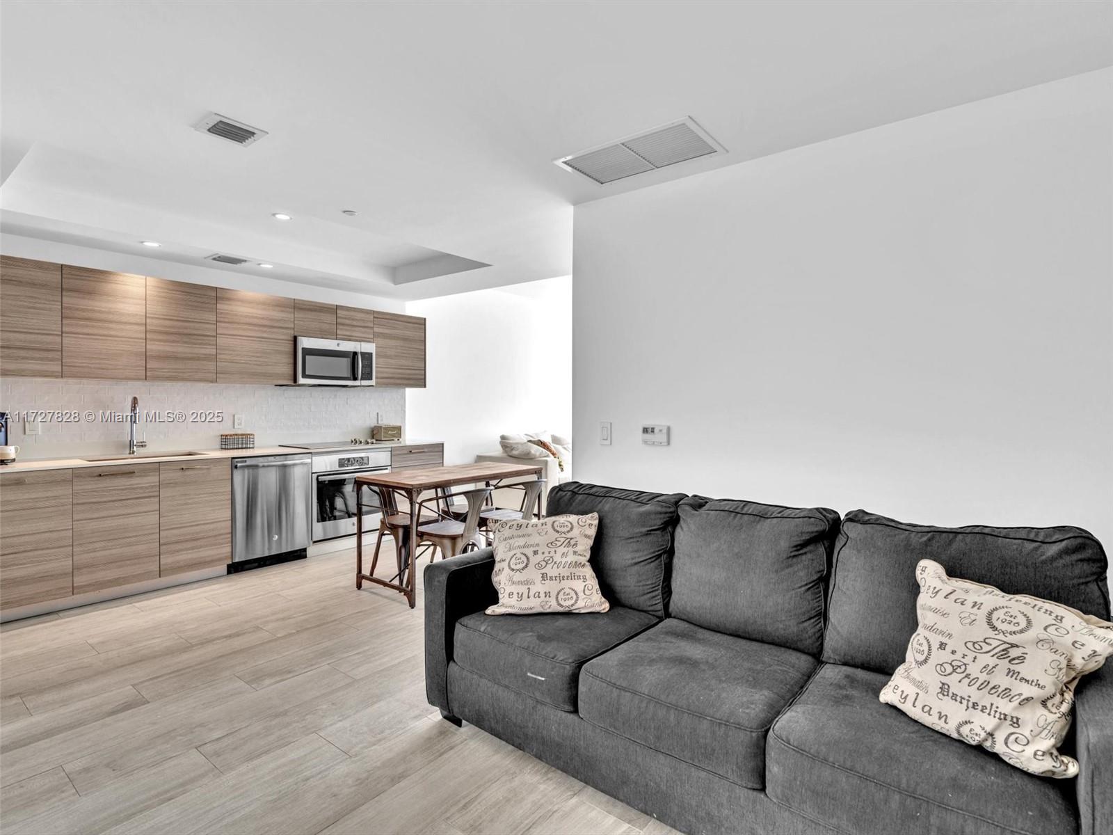 121 Northeast 34th Street, Unit 1005 Miami, FL 33137 - Photo 7 of 44 a living room with furniture and kitchen view