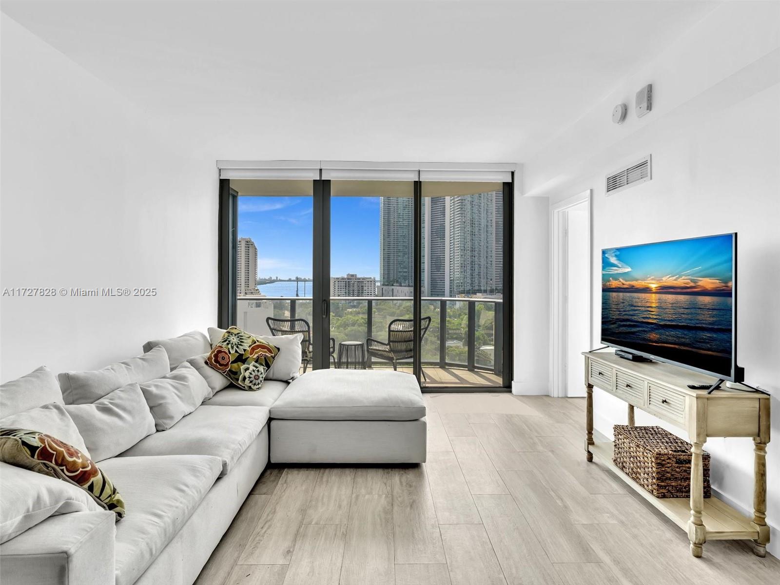 121 Northeast 34th Street, Unit 1005 Miami, FL 33137 - Photo 9 of 44 a living room with furniture and a flat screen tv