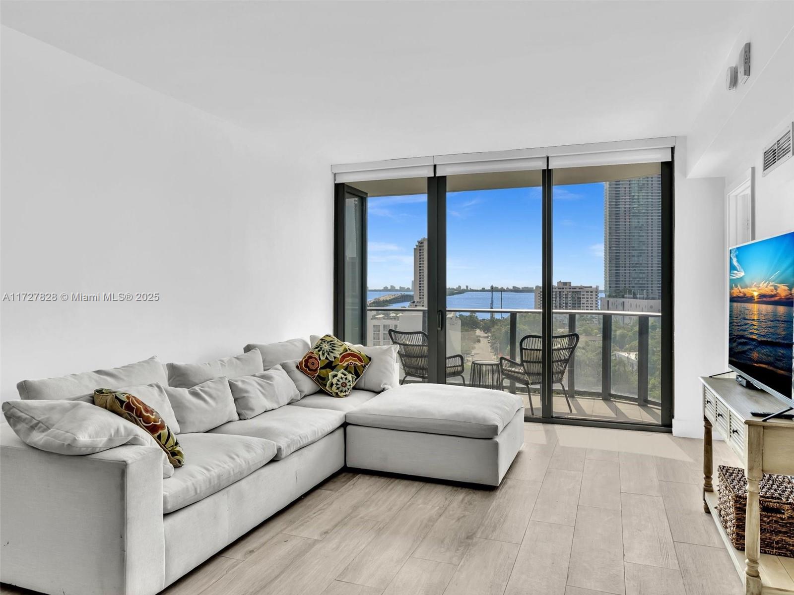 121 Northeast 34th Street, Unit 1005 Miami, FL 33137 - Photo 10 of 44 a living room with furniture and a flat screen tv