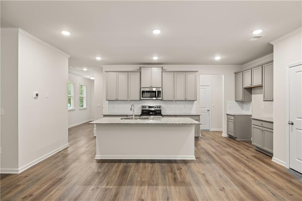 4516 Ajo Walk Atlanta, GA 30331 - Photo 6 of 13 a large kitchen with stainless steel appliances granite countertop a stove a sink dishwasher and a refrigerator with wooden floor