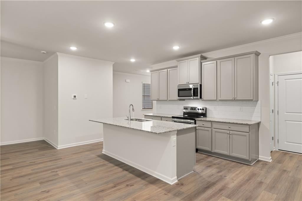4516 Ajo Walk Atlanta, GA 30331 - Photo 7 of 13 a kitchen with stainless steel appliances granite countertop a stove top oven a sink and white cabinets