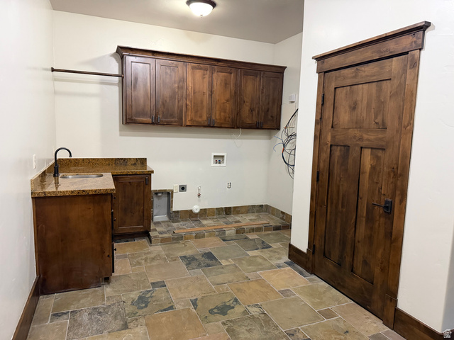 4536 North 475 East Provo, UT 84604 - Photo 26 of 65 Laundry room featuring a utility sink with a stone-finish countertop, wood-finish cabinetry, and slate-style tile flooring