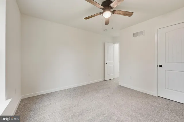 an empty room with a fan and a fan